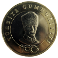 Rewers (?): Na pierścieniu wzdłuż krawędzi nazwa państwa: TÜRKIYE CUMHURIYETI. Na dole, częściowo na krążku, logo Stulecia Republiki Turcji; Na krążku portret Mustafy Kemala Atatürka