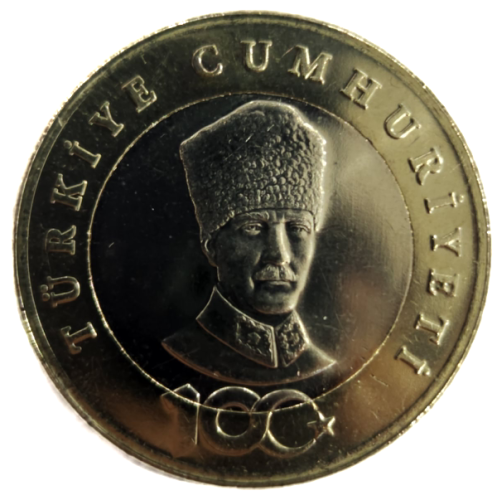 Rewers (?): Na pierścieniu wzdłuż krawędzi nazwa państwa: TÜRKIYE CUMHURIYETI. Na dole, częściowo na krążku, logo Stulecia Republiki Turcji; Na krążku portret Mustafy Kemala Atatürka